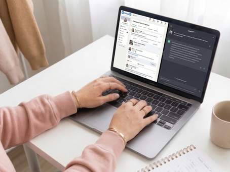 Hands typing on a laptop in a cozy room with beige sweaters hanging. Screen shows LinkedIn and ChatGPT. Notebook, succulent, and mug nearby.