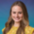 Smiling young woman with long light brown hair wearing a yellow floral top, photographed against a blue-green gradient background.