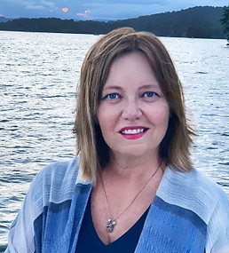 Roxann Christle Smith smiling in front of the water at sunset