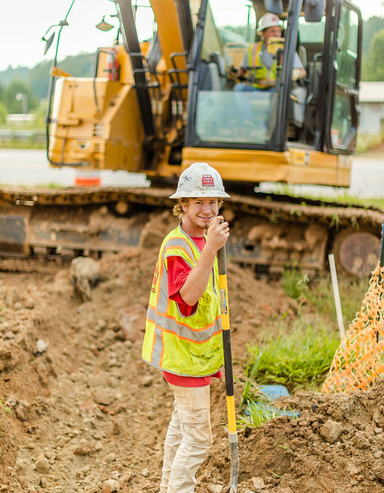 Man smiling and holding a shovel during residential development