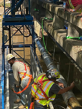 Men working on water lines along a bridge