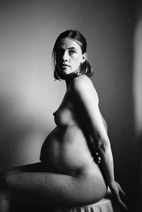 full body nude art portrait of a pregnant young woman in black and white analog film Ilford XP2