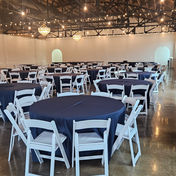 Company party indoors with tables chairs and blue linens
