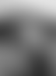 A person with a striking Iroquois-inspired haircut stands out in a public setting, his attention focused on his phone, merging modern tech with traditional style.