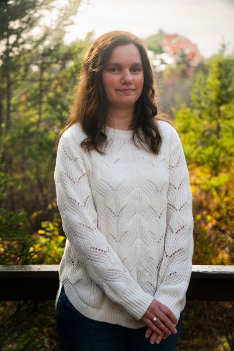 Professional outdoor portrait of woman standing in wooded autumn setting