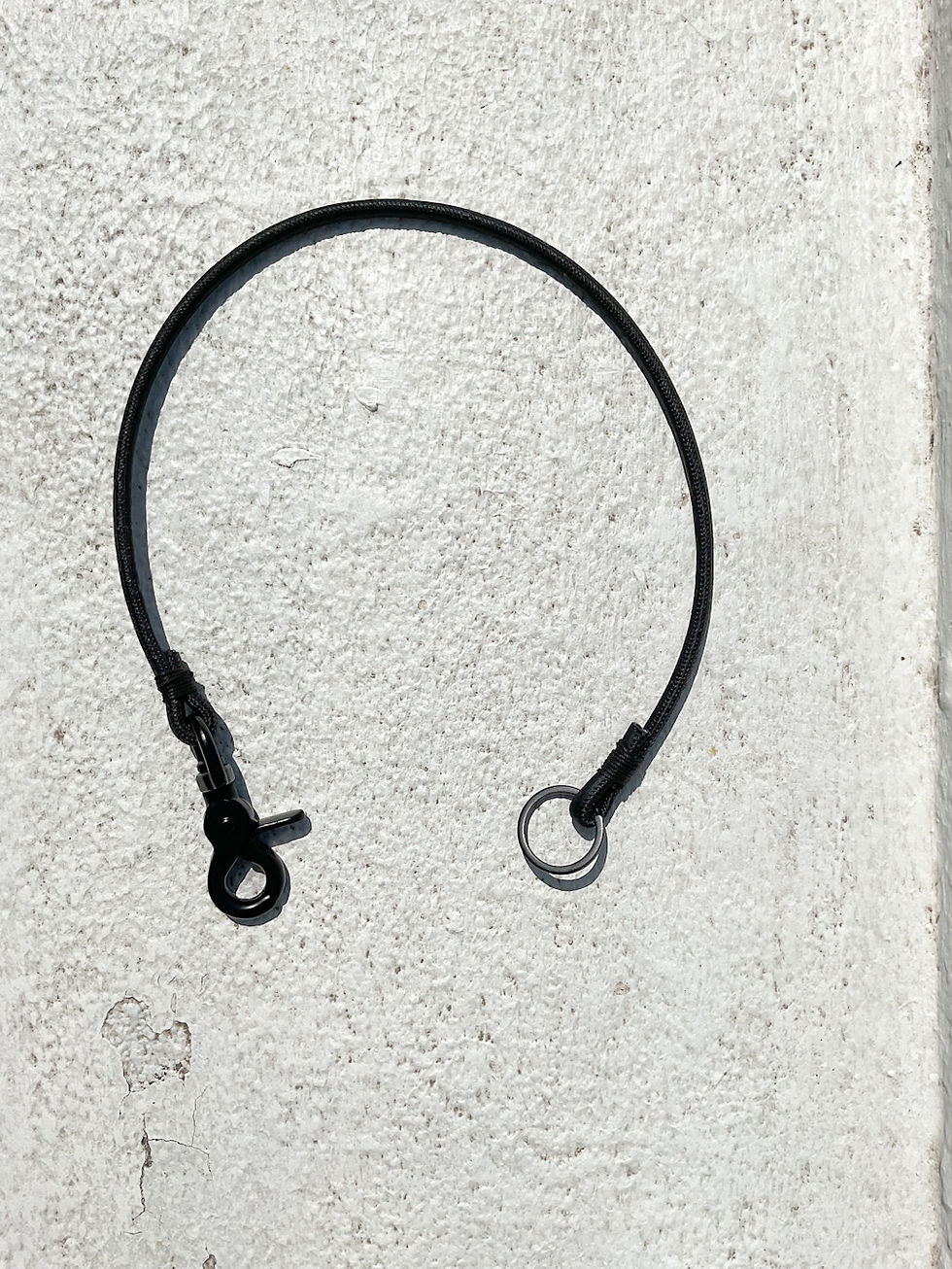 Miniaturbild: Ein Wallet- Lanyard aus schwarzem Kork, Karabiner und Schlüsselring liegt auf einem weißen Hintergrund.