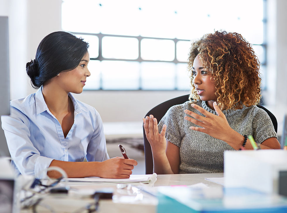 Two women talking earnestly in a corporate environment