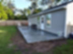 Newly installed concrete patio behind a house