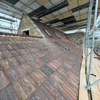 Roof renovation scene under a large scaffolding structure