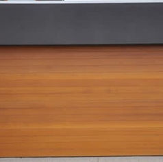 Smooth wooden garage door with horizontal grain and a dark gray lintel above