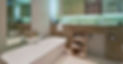 Modern bathroom with a sleek white bathtub, marble countertop, and shelves holding folded towels