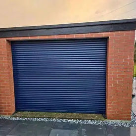 A blue roller garage door set within a red brick frame