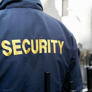 Close up view of the back of a blue security uniform jacket with yellow text lettering
