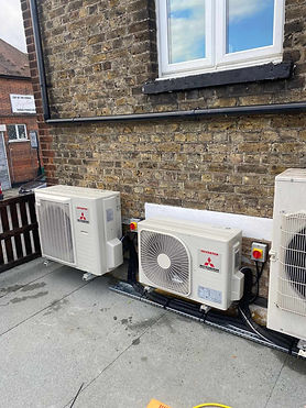Outdoor air conditioning units mounted on a red brick wall