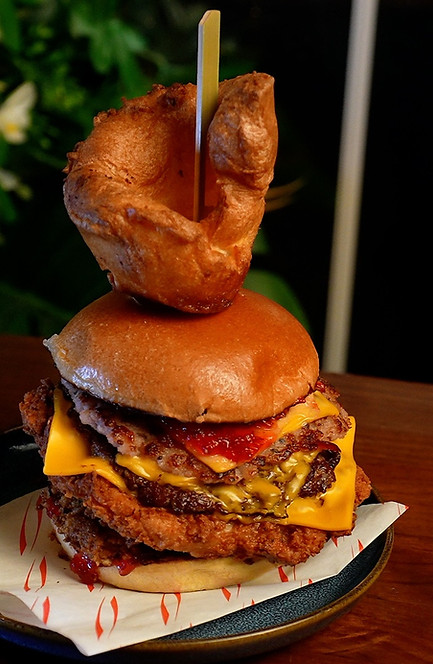 Stacked burger with fried chicken and Yorkshire pudding on top