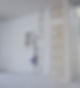 Unfinished interior wall with exposed wires and drywall patches