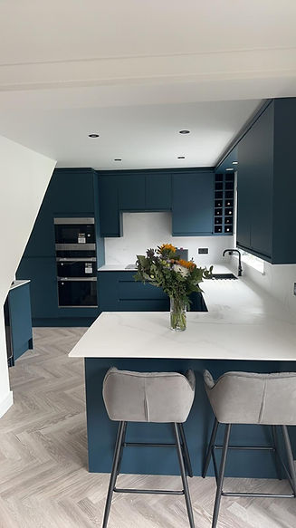 Modern kitchen with dark blue cabinets, white countertops