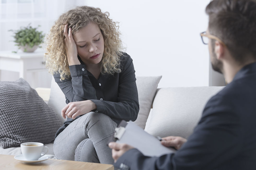 Young worried woman touching her head during psychotherapy.jpg