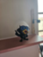 Petite figurine oiseau, casque blanc, doigt levé