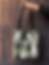 mockup-of-a-woman-s-hand-holding-a-tote-bag-against-a-wooden-background-26693.png