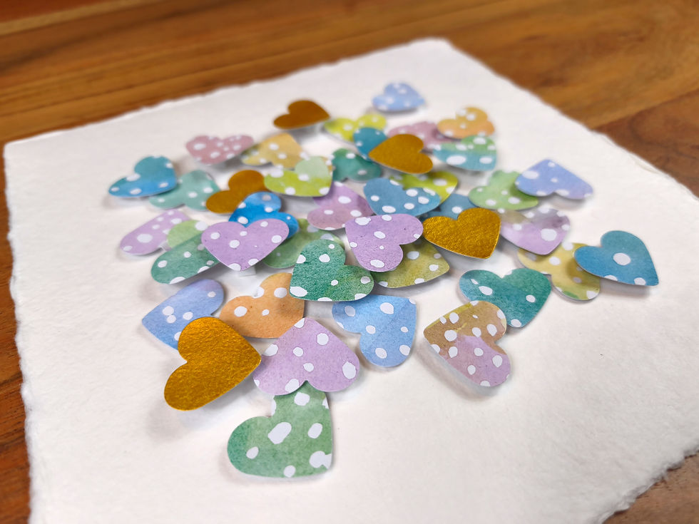 Thumbnail: Herzen in Pastellfarben mit weißen Punkten, dazwischen goldene Herzen auf Büttenpapier