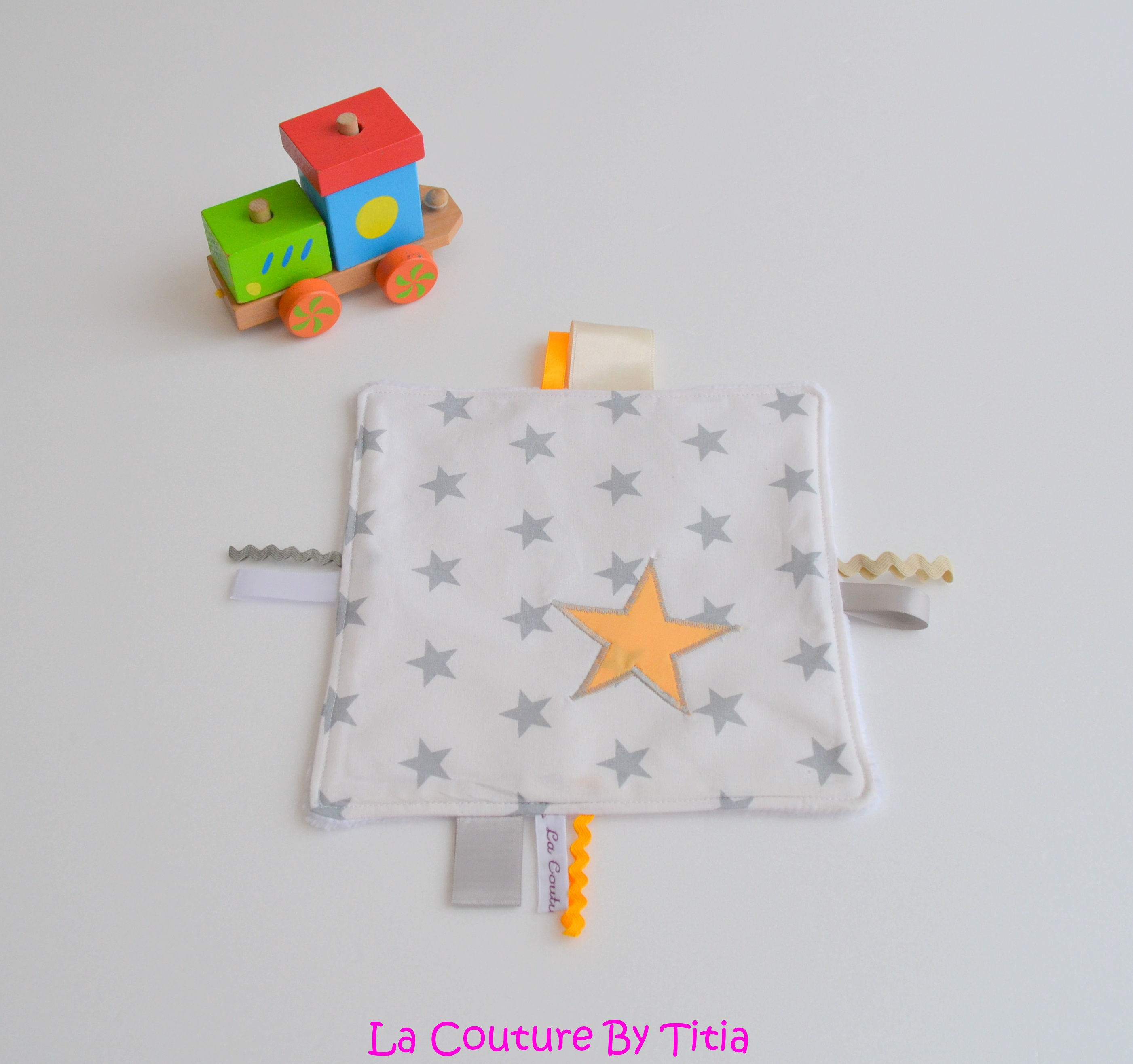 Doudou étiquette blanc gris et étoiles clémentine