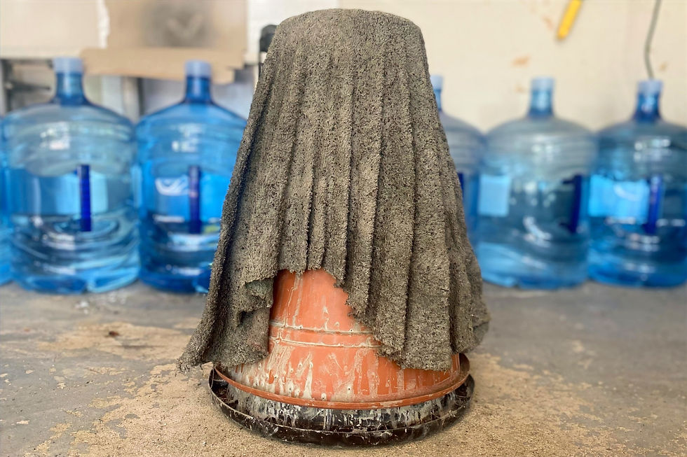 a towel that has been dipped in concrete draped over an upside down bucket to dry