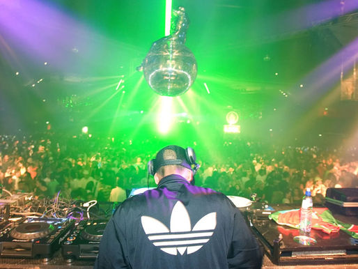 Um DJ se apresentando para uma multidão.