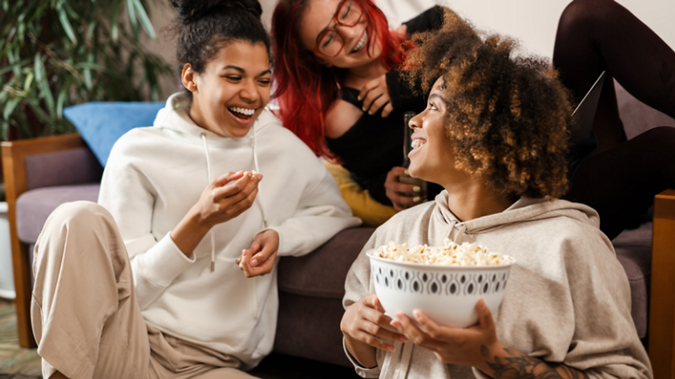 3 individuals socializing and eating popcorn