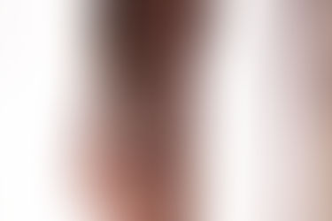 Close up boudoir photo of a woman from behind. She's wearing strappy black lingerie and her hands are grasping her bottom.