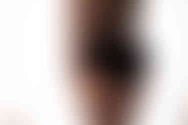 Detail boudoir photo of plus sized woman from behind, wearing black lingerie.