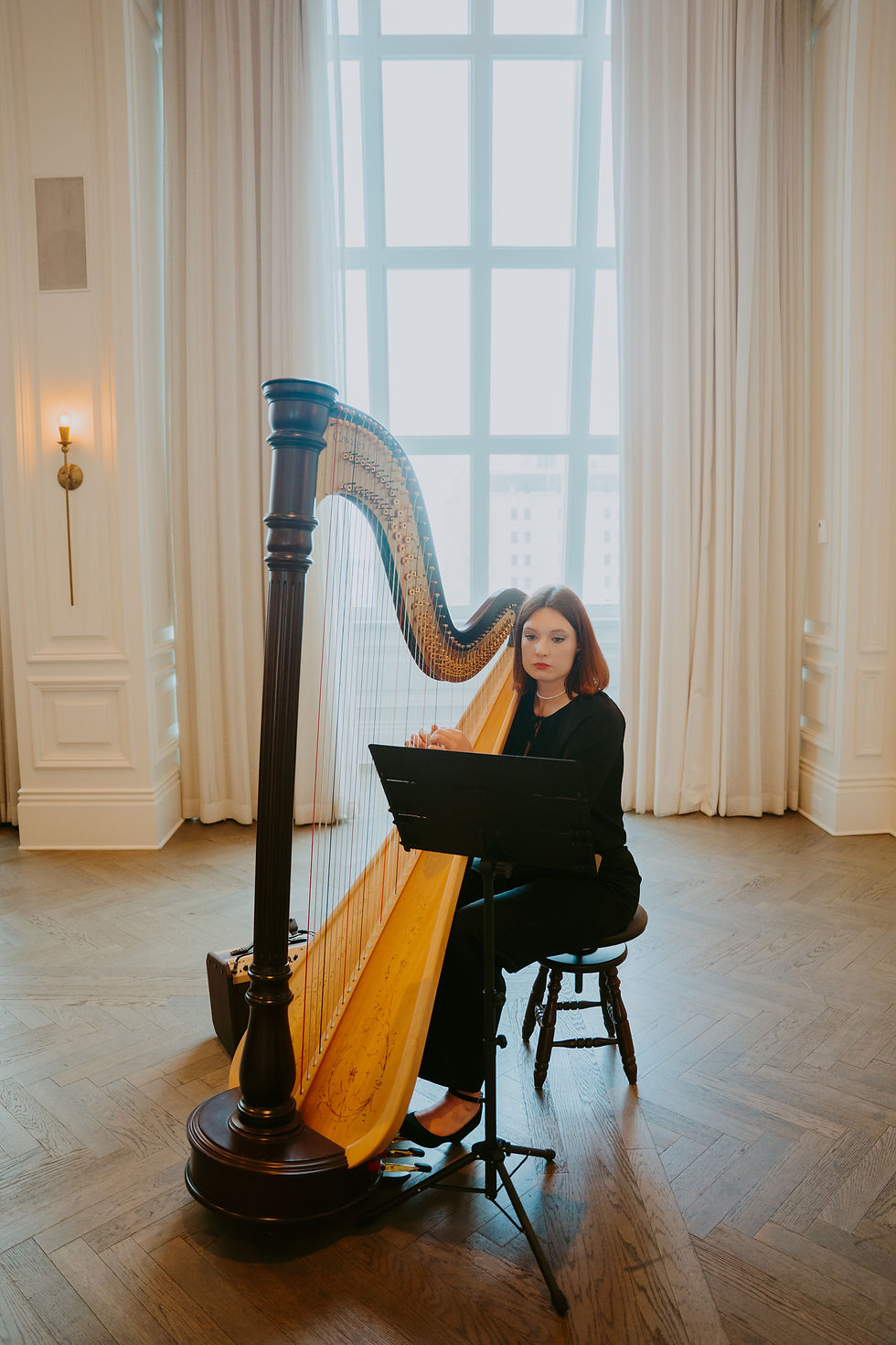 Woman playing the harp for a wedding at the Adolphus Hotel in Dallas, Texas. 