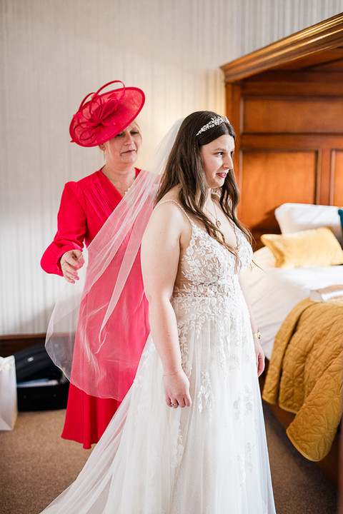 brides mam helping her with her veil
