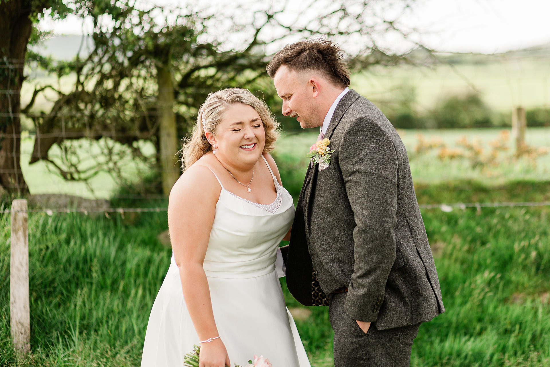 bride laughing at a joke said by the groom