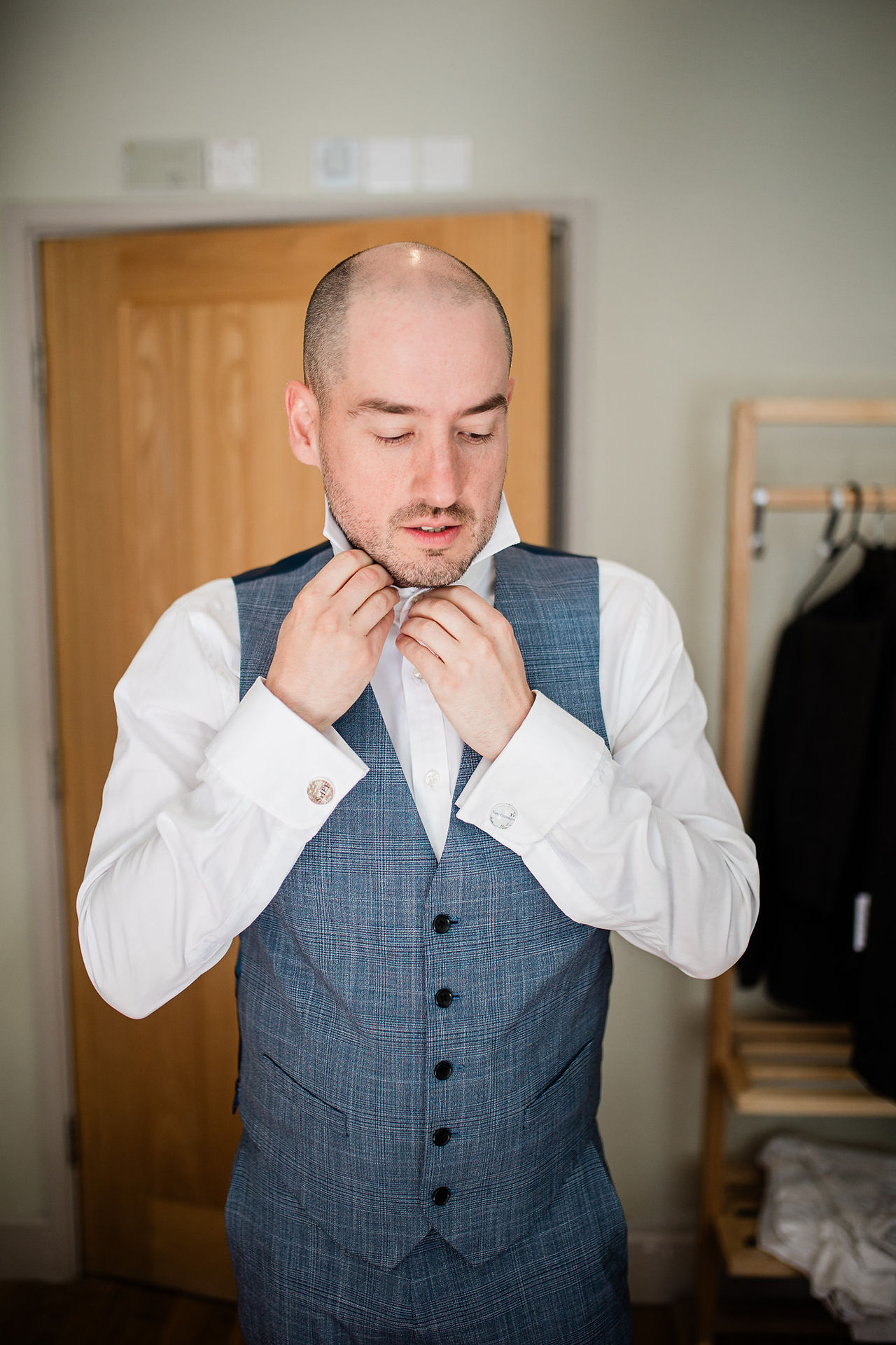 Glyn tying his tie during groom prep.