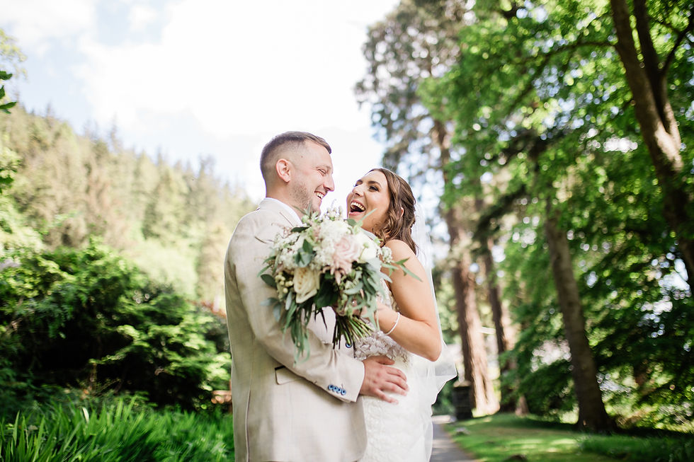 A couple laughing while holding each other near a forestry
