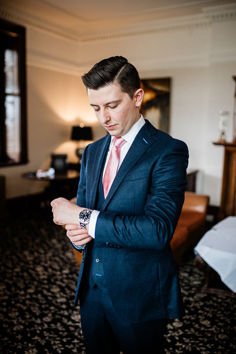 Groom straightening his watch
