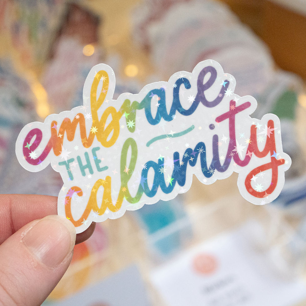 Thumbnail: Holographic sticker reading 'embrace the calamity' in handwritten, bold, cursive rainbow text.
