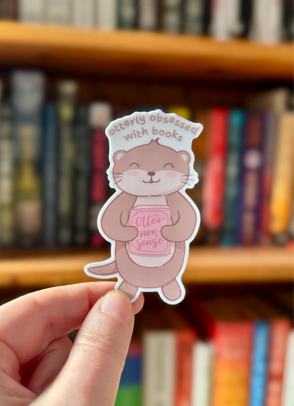 Thumbnail: image of sticker of cute kawaii-style otter, holding a book named 'otter nonsense', with text 'otterly obsessed with books'