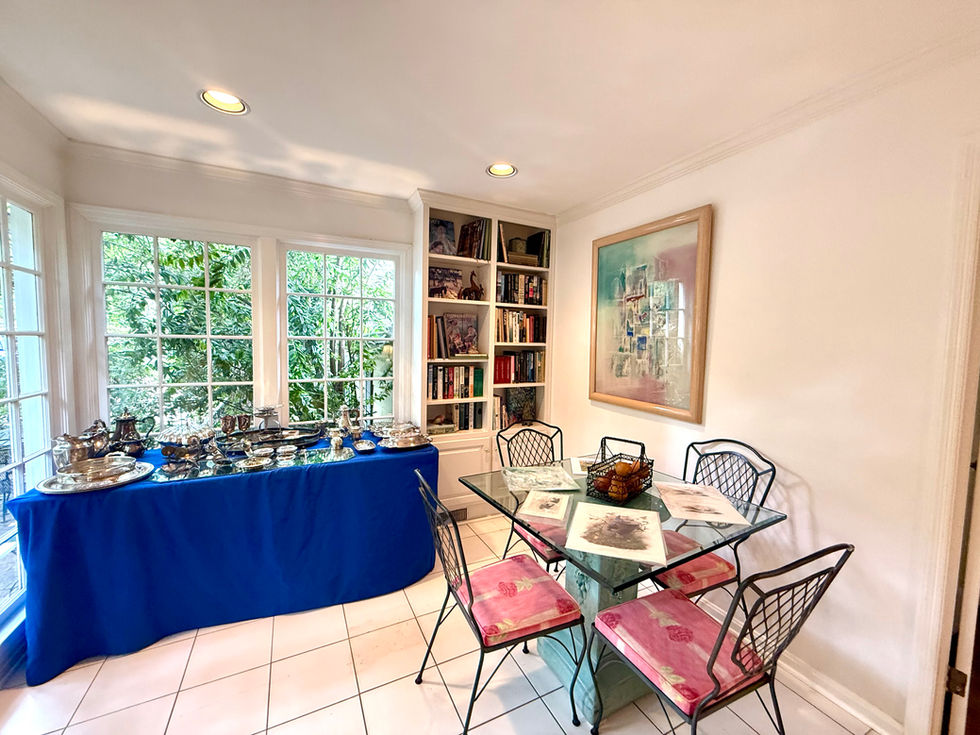 Bright room with glass table and bookshelf.