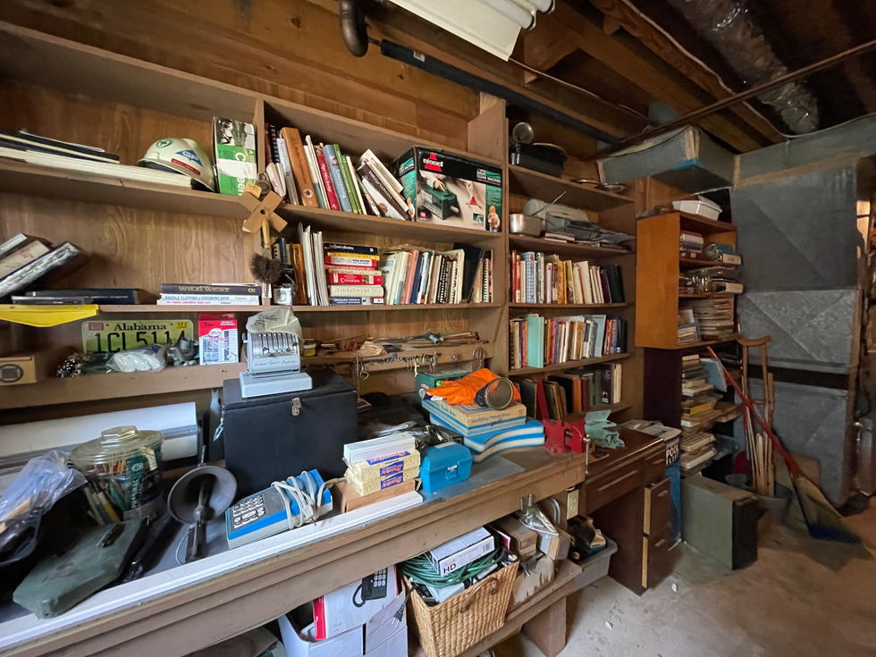 a cluttered room with a alabama license plate