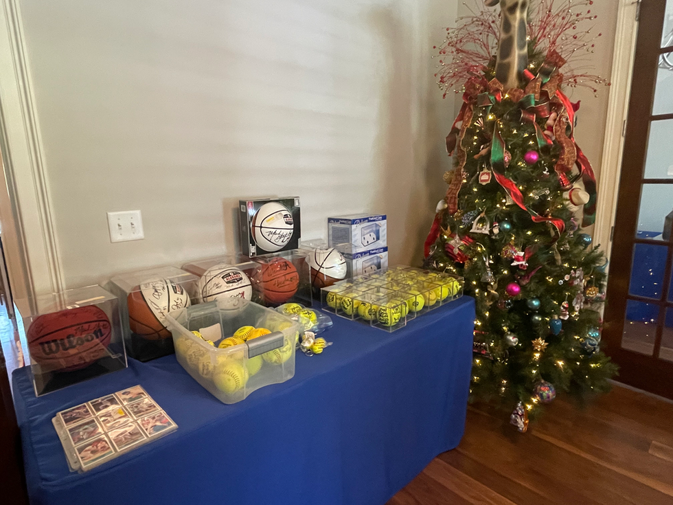 a table with basketballs and baseballs on it in front of a christmas tree
