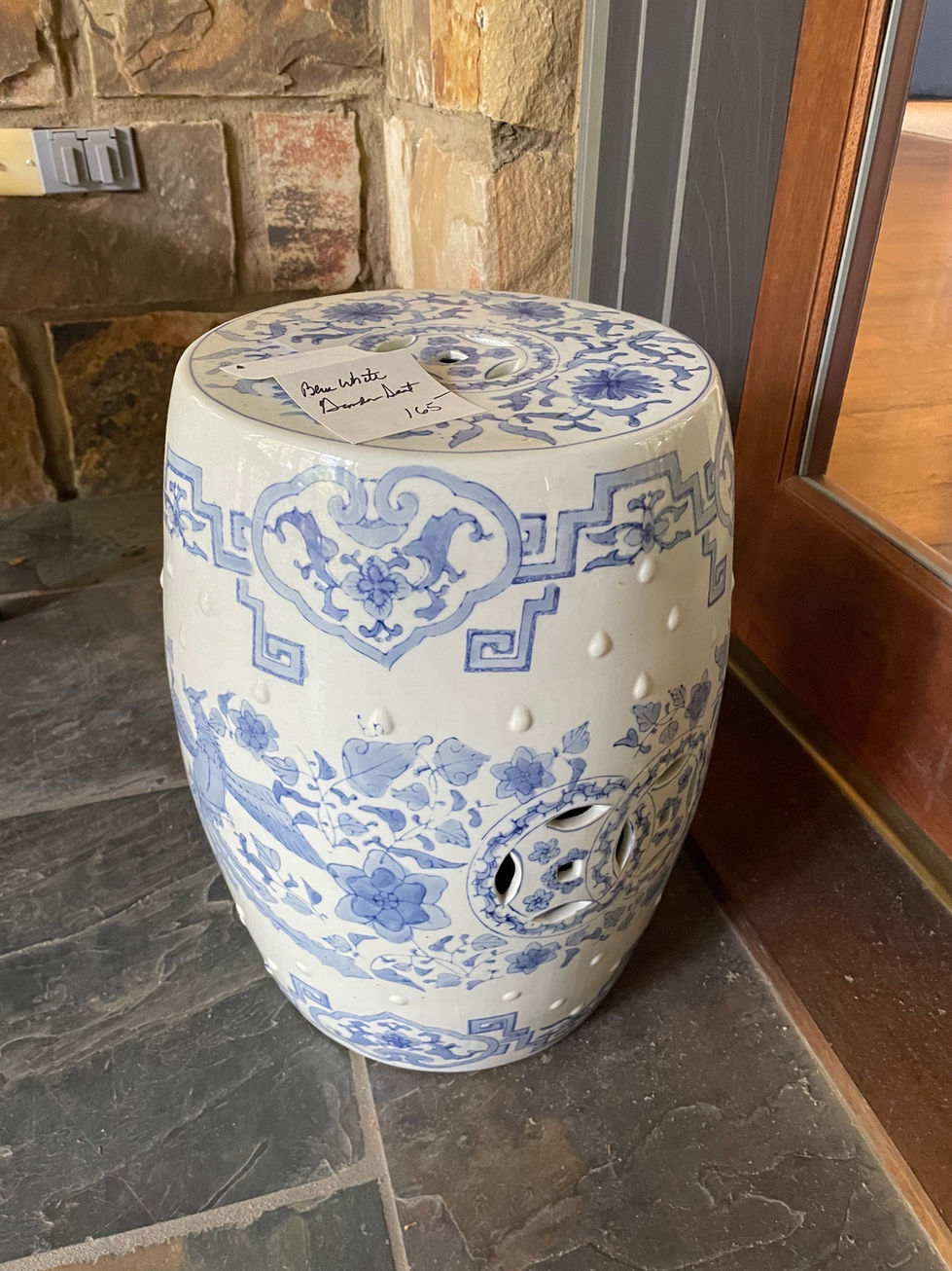 a blue and white ceramic stool with a label that says blue white bucket