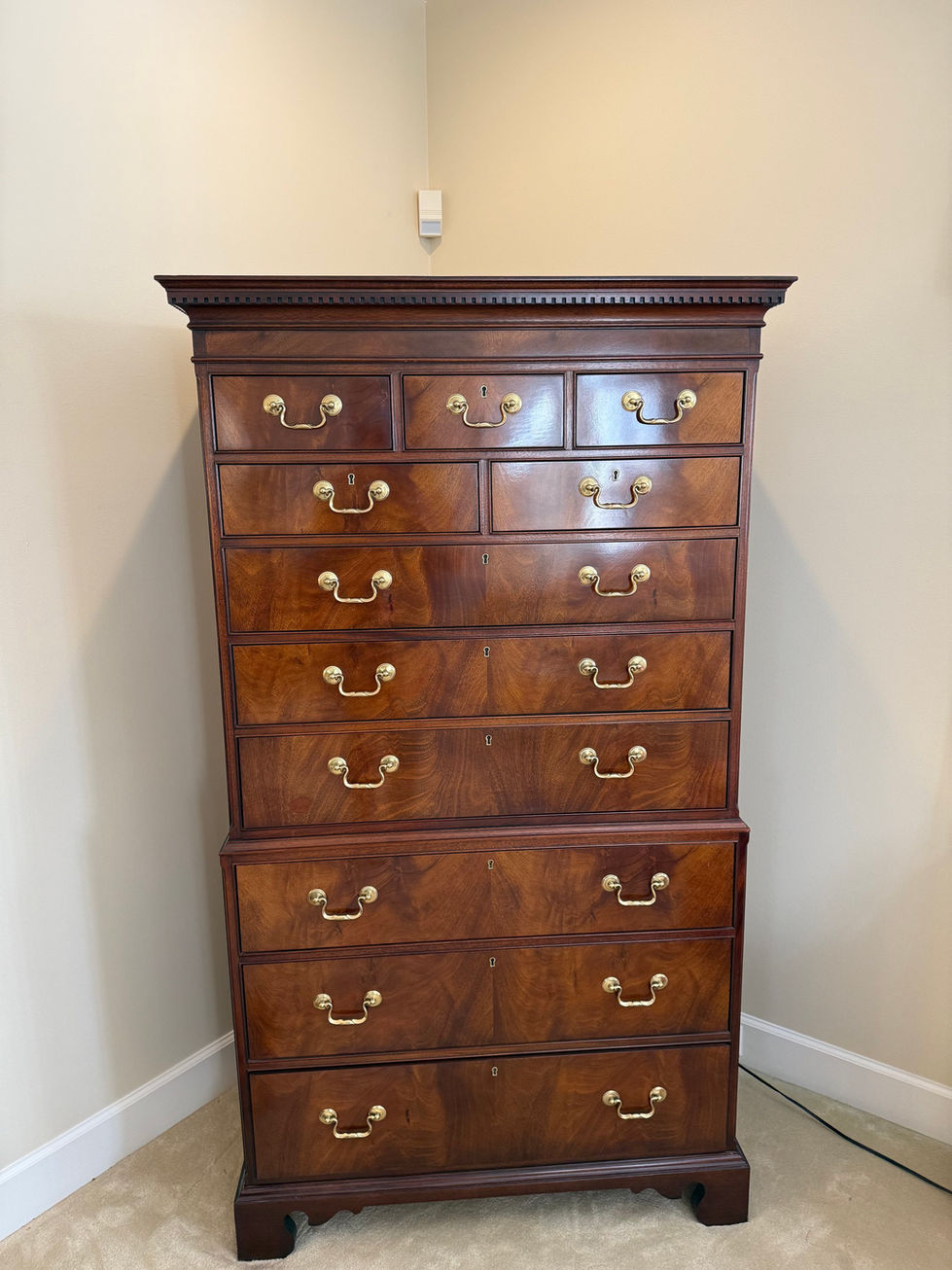 a wooden chest of drawers with brass handles has the number 8 on it