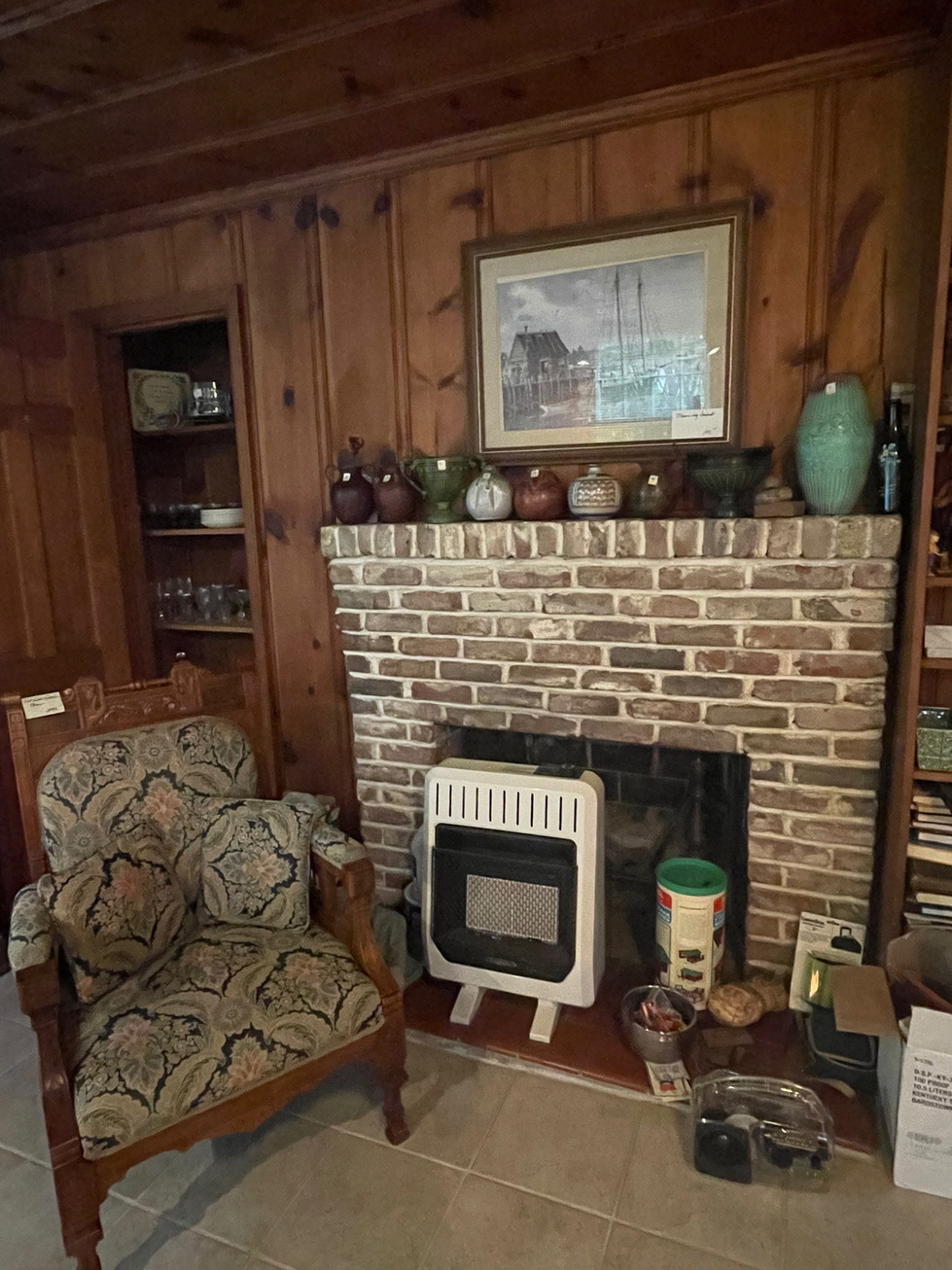 a living room with a brick fireplace and a chair