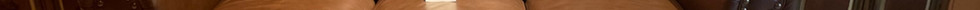 a brown leather couch sits next to a wooden coffee table