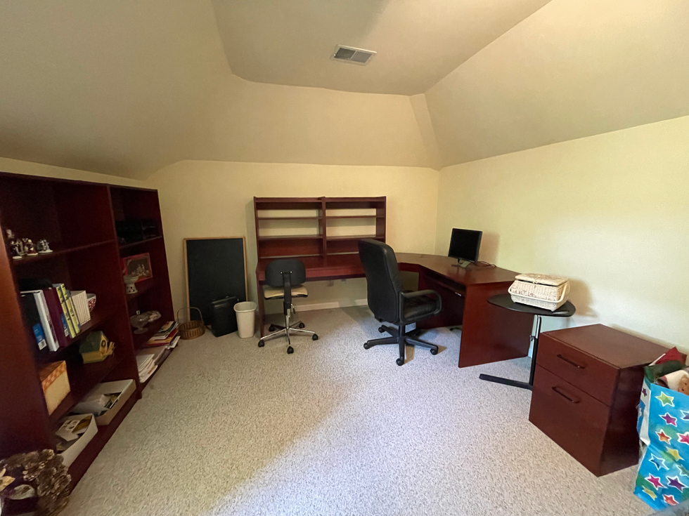 a corner of a room with a desk and chair