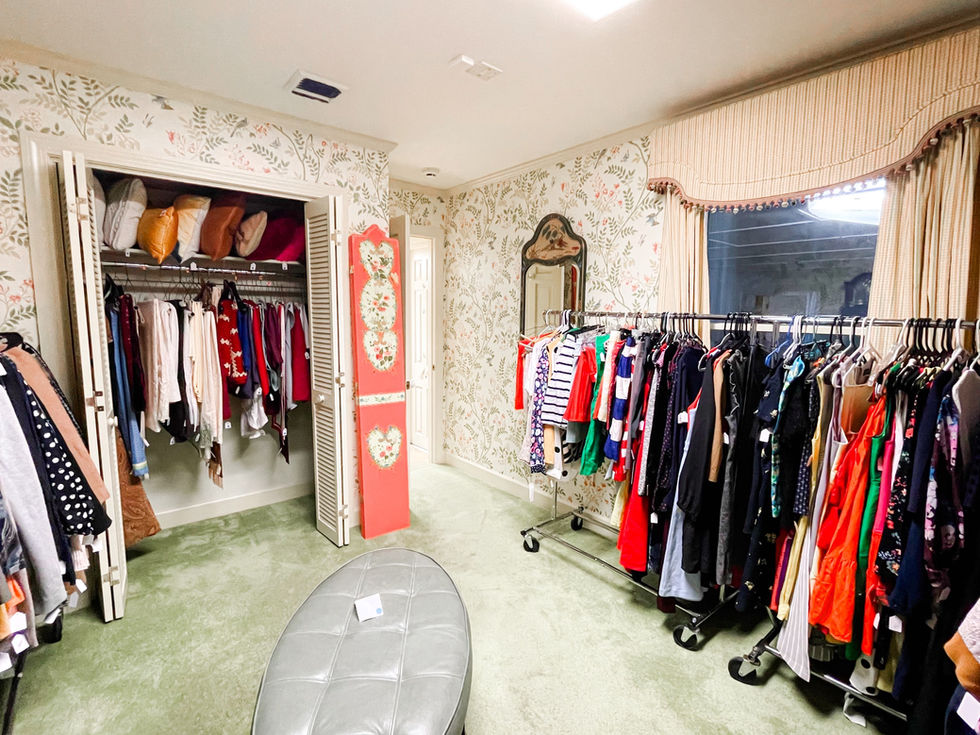 a closet with clothes hanging on racks and a mirror