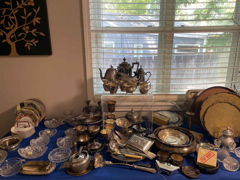 a table full of silverware including a box that says ' antique ' on it