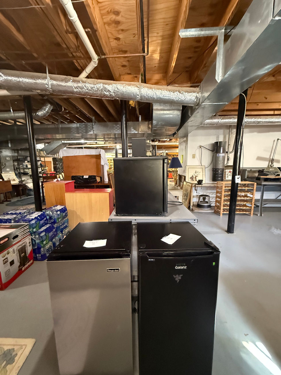 a stainless steel refrigerator and a black granitz refrigerator sit in a store